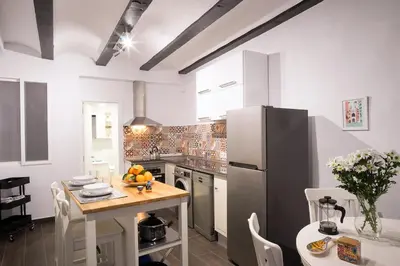 a kitchen with a table and a refrigerator at Window to Central Market in Valencia