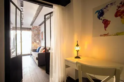 a living room with a table with a lamp on it at Window to Central Market in Valencia