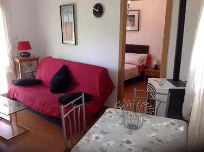 a living room with a red couch and a table at Casita Ramona in Valencia