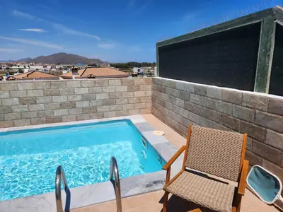 a swimming pool with a chair next to a brick wall at Apartment in Vera with rooftop pool in Valencia