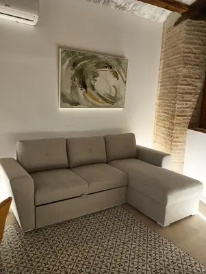 a couch in a living room with a painting on the wall at Apartamentos Valencia Centro 1 in Valencia