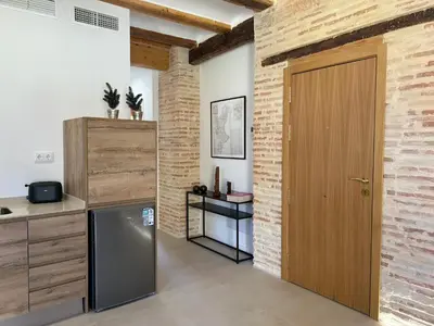 a kitchen with a refrigerator and a wooden door at Apartamentos Valencia Centro 1 in Valencia