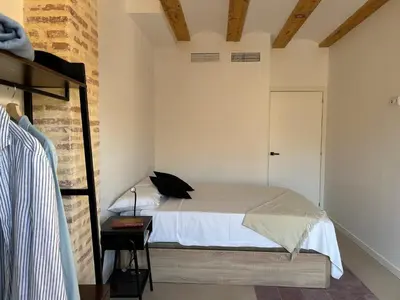 a bedroom with a bed and a brick wall at Apartamentos Valencia Centro 1 in Valencia