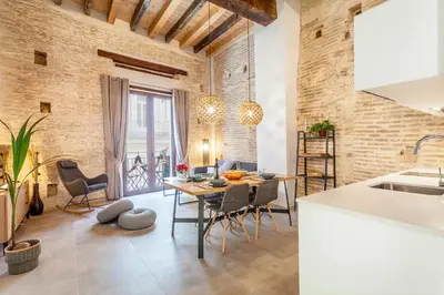a kitchen and dining room with a table and chairs at Bolseria Ciutat Vella in Valencia