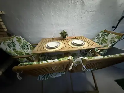 a wooden table with two plates and a plant on it at Duplex Ático con terraza y BBQ in Puerto de Sagunto