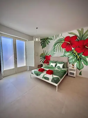a bedroom with a bed with red flowers on the wall at Glamour Suite 2 next to the city center in Valencia
