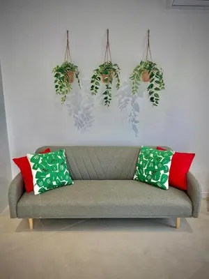a couch in a living room with plants on the wall at Glamour Suite 2 next to the city center in Valencia