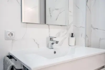 a white bathroom with a sink and a mirror at Duplex-Port-Valencia 14 in Valencia