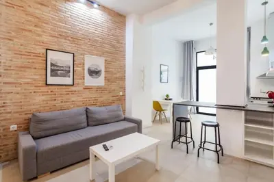 a living room with a couch and a kitchen at New Flat center historic Ruzafa Wifi AC in Valencia