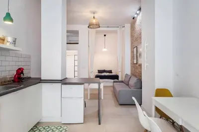 a kitchen and living room with a table and a couch at New Flat center historic Ruzafa Wifi AC in Valencia
