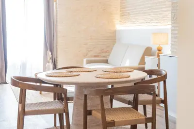 a table and chairs in a living room with a refrigerator at Yturralde by Alma Suites in Valencia