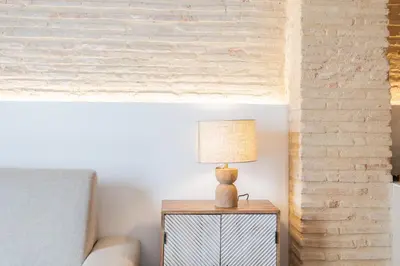 a lamp on a table next to a bed at Yturralde by Alma Suites in Valencia