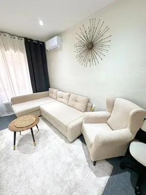 a living room with a couch and chairs and a clock at La montaña del sol in Sueca