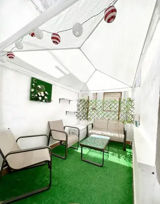 a living room with white furniture and green carpet at La montaña del sol in Sueca