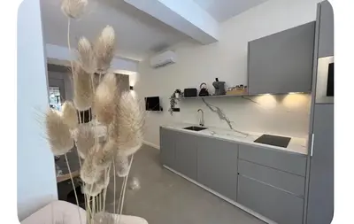 a white kitchen with a sink and a counter at Cosy apartment between beach and city centre in Valencia
