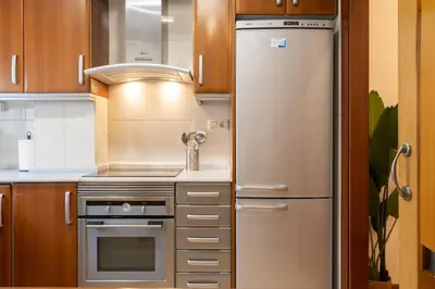 a stainless steel refrigerator in a kitchen with wooden cabinets at Alojamiento Centrico para 6 Personas in Valencia