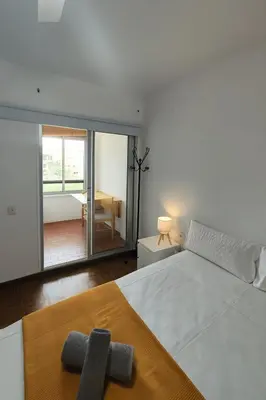 a bedroom with a large white bed and a balcony at Apartamento Familiar En Nuevo Centro - Parque Central Turia in Valencia