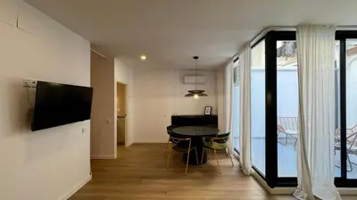 a living room with a dining room table and a television at Boutique Room - Vila Prades in Valencia