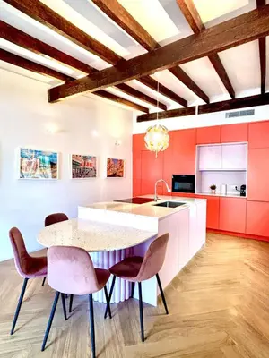 a kitchen with red cabinets and a table and chairs at Casa Tossal in Valencia