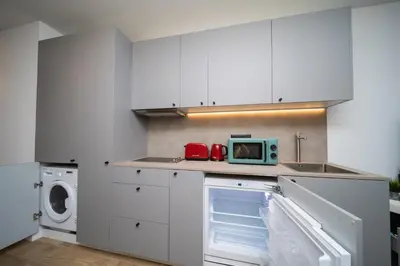 a kitchen with white cabinets and a sink and a microwave at Cielo y Mar in Valencia