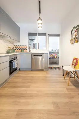 a kitchen with stainless steel appliances and a wooden floor at Valencia Designer Apartment next to metro in Paterna
