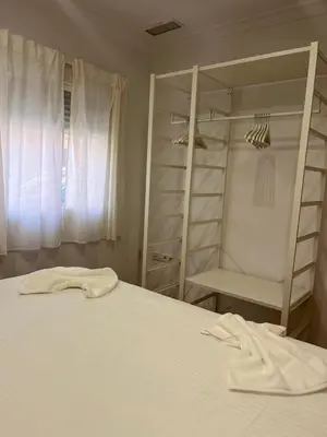 a bedroom with a white bed and a closet at Terraza 120 m2 y paellero - Metro & Aeropuerto in Manises