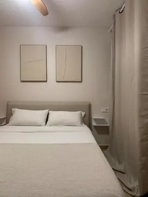 a bed in a room with two pictures on the wall at Cosy Flat Valencia in Masanasa