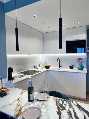 a kitchen with white cabinets and a table with wine glasses at Alameda Stay - Apartamento lujoso Ciudad de las Artes y las Ciencias in Valencia