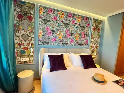 a bedroom with a white bed with a floral wall at Alameda Stay - Apartamento lujoso Ciudad de las Artes y las Ciencias in Valencia