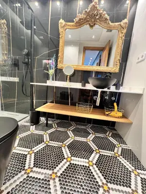 a bathroom with a mirror and a black and white tiled floor at Alameda Stay - Apartamento lujoso Ciudad de las Artes y las Ciencias in Valencia