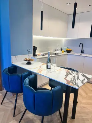 a kitchen with a table and blue chairs at Alameda Stay - Apartamento lujoso Ciudad de las Artes y las Ciencias in Valencia