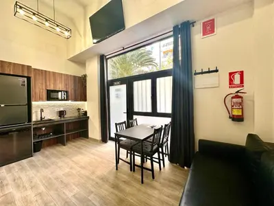 a living room with a table and a kitchen at Ciudades de España in Valencia