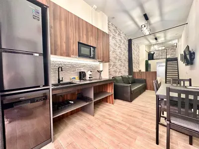 a living room with a large television and a kitchen at Ciudades de España in Valencia