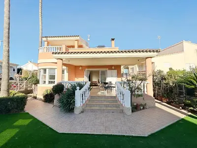 a drink sitting on a table next to a swimming pool at Villa en la Playa I 5BR I 5 WC I Piscina Privada in Sueca