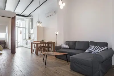 a kitchen with white cabinets and a wooden floor at House near beach w-terrace in Valencia