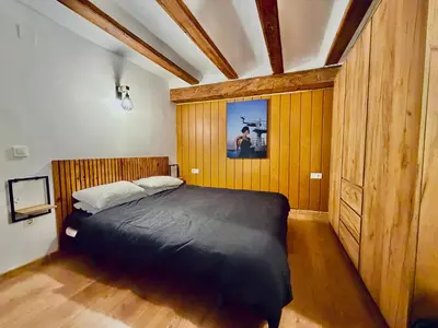 a bedroom with a bed in a room with wooden walls at Duplex en el Carmen in Valencia