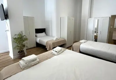 a hotel room with two beds and a mirror at Urban loft Benicalap in Valencia