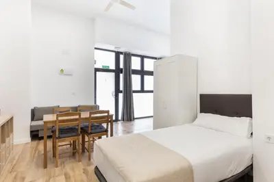 a bedroom with a bed and a table and chairs at Urban loft Benicalap in Valencia