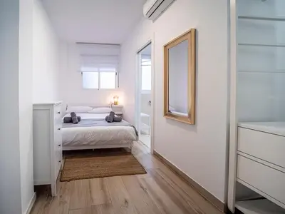 a white bedroom with a bed and a mirror at Apartment Ruzafa Market 6B in Valencia
