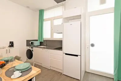 a kitchen with a white refrigerator and a table at GuestReady - Fontilles apartments in Valencia