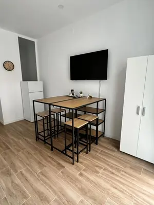a dining room with a table and chairs and a flat screen tv at Habitacion privada con baño privado II in Valencia