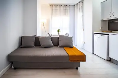 a couch in a room with a kitchen at Apartment Ruzafa Market 7B in Valencia