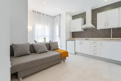 a living room with a couch and a kitchen at Apartment Ruzafa Market 7B in Valencia