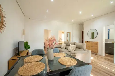 a living room with a glass table and blue chairs at ChillOut Area 2BR 4P City Relax Fast WiFi Pet Friendly in Valencia