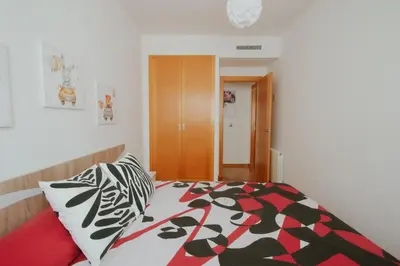 a bedroom with a bed with a black and white comforter at Family & Friends Apartment with Pool in Torrent