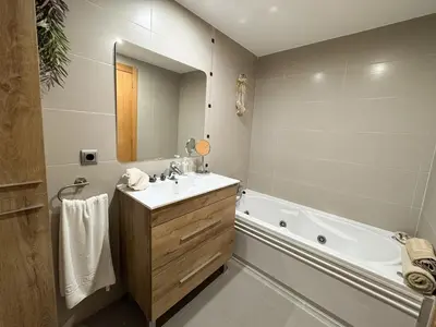 a bathroom with a tub and a sink and a bath tub at Family & Friends Apartment with Pool in Torrent