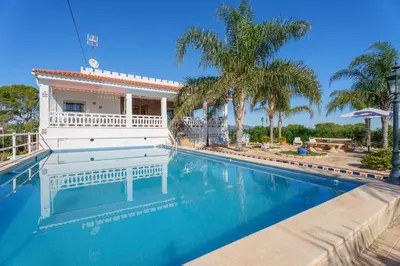 a swimming pool in front of a house with palm trees at Masia Miliuca Paraíso rural a un paso de Valencia - Rural paradise close to Valencia in Bétera
