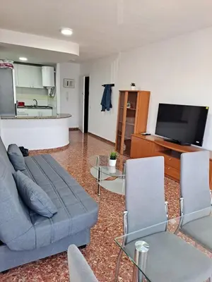 a living room with a couch and chairs and a tv at Comfortable apartment in the Feria 2 area in Valencia