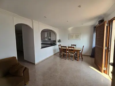a kitchen and dining room with a table and chairs at Apartamento en Primera Linea de Playa en Mareny de Barraquetes-Vistas al Mar-El Refugio del Mediterráneo in Mareny Barraquetas