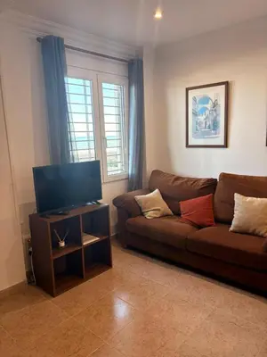a living room with a couch and a flat screen tv at Apartamento en Primera Linea de Playa en Mareny de Barraquetes-Vistas al Mar-El Refugio del Mediterráneo in Mareny Barraquetas